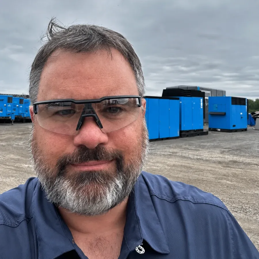 Frédérik Lavoie, président d’Onyx M3, sur un site industriel devant des compresseurs d’air