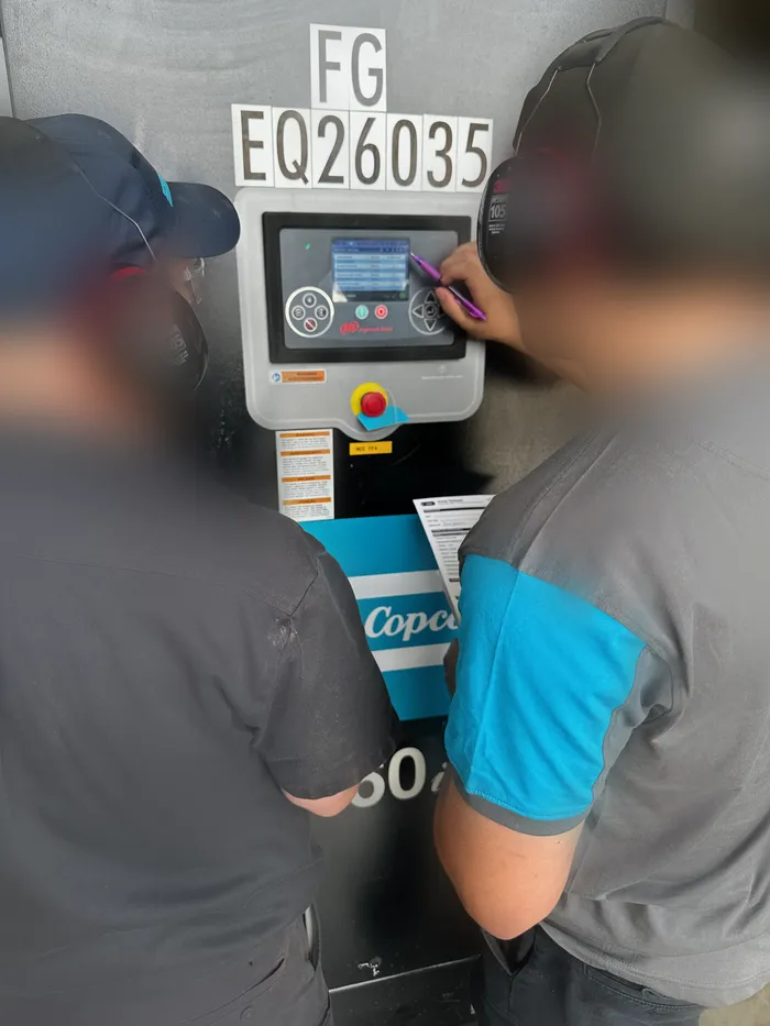 Deux opérateurs apprenant à utiliser le contrôleur du compresseur en usine